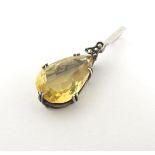 A silver pendant set with facet cut pear shaped citrine drop with marcasite detail.