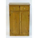 An early / mid 20thC pine cupboard with a rectangular top above two short drawers and two panelled