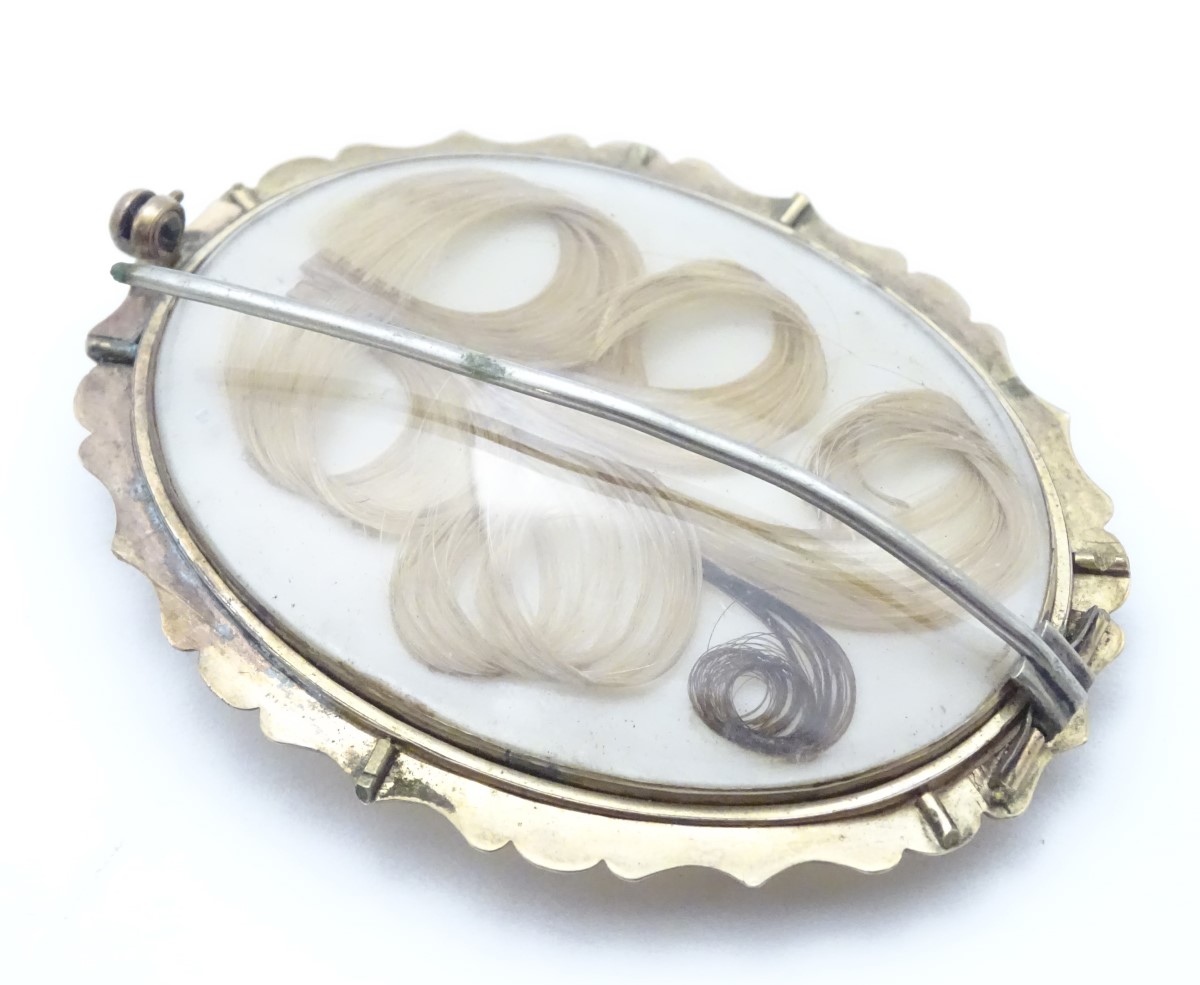 A 19thC oval brooch set with chalcedony cabochon to one side and memorial / mourning lock of hair - Image 2 of 6