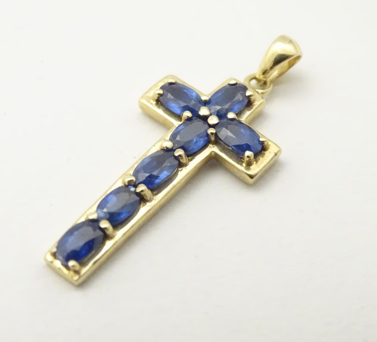 A 9ct gold cross formed pendant set with 7 topaz.