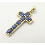 A 9ct gold cross formed pendant set with 7 topaz.