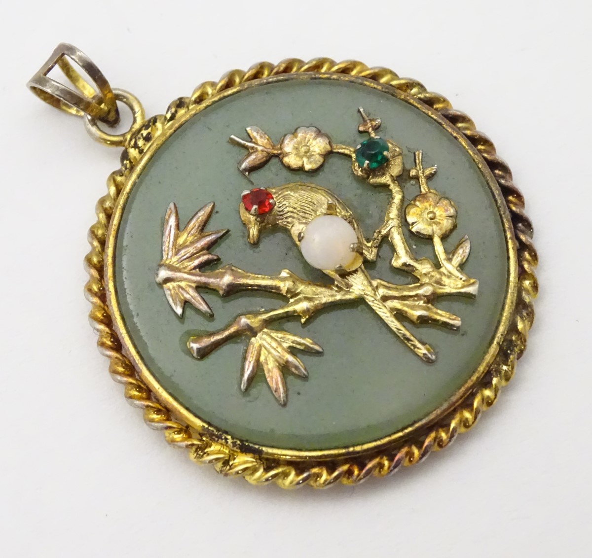An Oriental pendant of circular form set with jadite stone to centre with bird and foliate