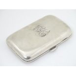 A silver cigarette / cigar case of shaped form with gilded interior.