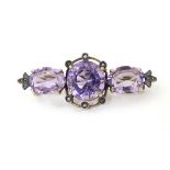 A late 19thC / early 20thC silver gilt brooch set with 3 amethysts and seed pearls,