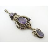A white metal pendant set with amethysts and seed pearls,