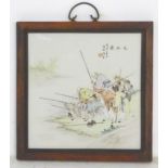 A 20thC Chinese wooden wall hanging with a porcelain panel depicting elders fishing on the bank of