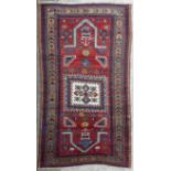 Tapis Kazakh à champ principal rouge parsemé des motifs géométriques bleus, [...]