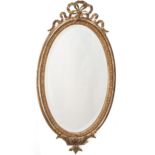 Miroir en bois et stuc doré à décor au sommet d'un ruban et de feuilles d'acanthe [...]