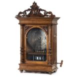 *Polyphon. A Victorian "penny slot" Polyphon, the walnut case with rococo scroll pediment, single
