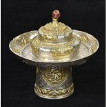 *Tibetan Silver. A 19th century Tibetan silver gilt pedestal bowl and cover with goldstone knop,