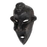 *Congo. A carved wood Pende sickness mask, the ferocious face surmounted with a smaller head, 30cm