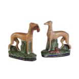 PAIR OF STAFFORDSHIRE POTTERY GREYHOUNDS painted in enamel colours on green moulded and blue gilt-
