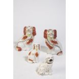 PAIR OF STAFFORDSHIRE POTTERY SPANIEL DOG MANTEL ORNAMENTS with moulded bodies, overglaze painted,