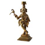 TWO INDIAN GILT BRONZE CANDLESTICKS, 20TH CENTURY, modelled as dancing figures, 28cm high