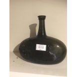 A GEORGE III DARK GREEN GLASS WINE BOTTLE