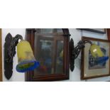 A PAIR OF FRENCH WROUGHT IRON WALL LIGHTS in the style of Edgar Brandt with yellow and blue glass