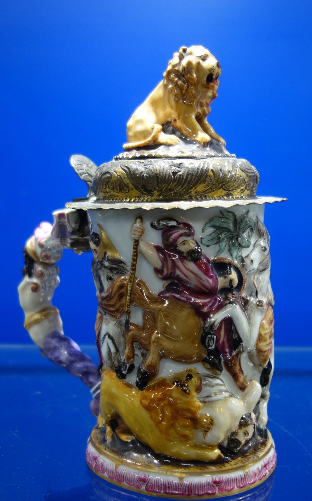 A CONTINENTAL 'DOCCIA' STYLE CERAMIC LIDDED TANKARD or stein, decorated with lions and hunters on