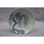 AN ORIENTAL BLUE AND WHITE SHALLOW DISH decorated with a willow tree