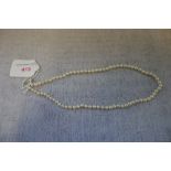 A CULTURED PEARL NECKLACE, each pearl knotted and terminating onto a 9ct yellow gold clasp, 45cm