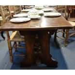 A GOTHIC STYLE OAK REFECTORY TABLE, with tracery design to the support, wedged stretchers and fitted