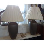 A PAIR OF CONTEMPORARY BROWN CERAMIC TABLE LAMPS with cream pleated shades