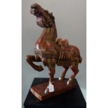 A CARVED RED LACQUER TANG STYLE HORSE, 20th century, modelled as the caparisoned rearing one leg