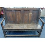 AN OAK SETTLE, with panelled back, incorporating much older, heavy timber, possibly from a ship