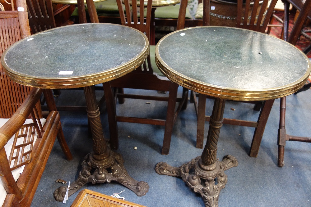 A PAIR OF FRENCH BRASS RIMMED CAFE TABLES, with cast iron bases and composition tops, each 51cm