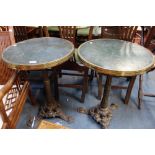 A PAIR OF FRENCH BRASS RIMMED CAFE TABLES, with cast iron bases and composition tops, each 51cm