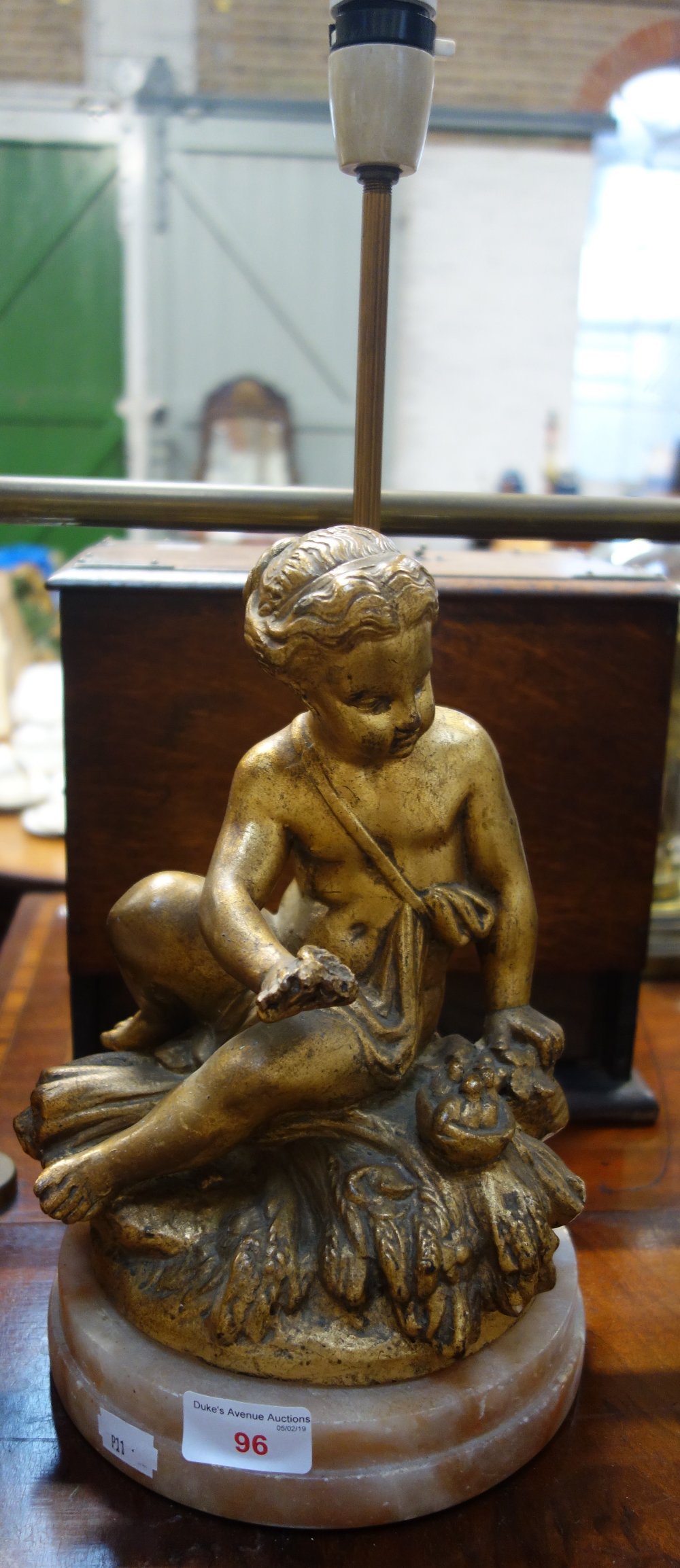 A TABLE LAMP decorated with a gilt cherub on an alabaster base