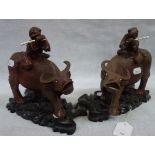 A PAIR OF CHINESE CARVED HARDWOOD BUFFALO, WITH RIDERS, on wooden stands, 20 cm high