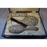 A SILVER BACKED FOUR PIECE DRESSING TABLE SET, comprising two brushes, hand mirror and comb, with