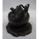 AN ORIENTAL BRONZE 'PEACH' on wooden stand, 8 cm high