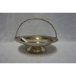 A SILVER BASKET, by Mappin & Webb, London, 1915, circular form with swing handle, cast foliate