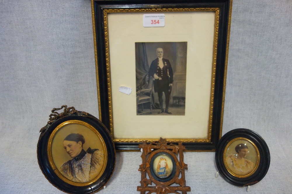 A MINIATURE PORTRAIT OF A YOUNG GIRL in a Black Forest carved frame, two other printed miniatures