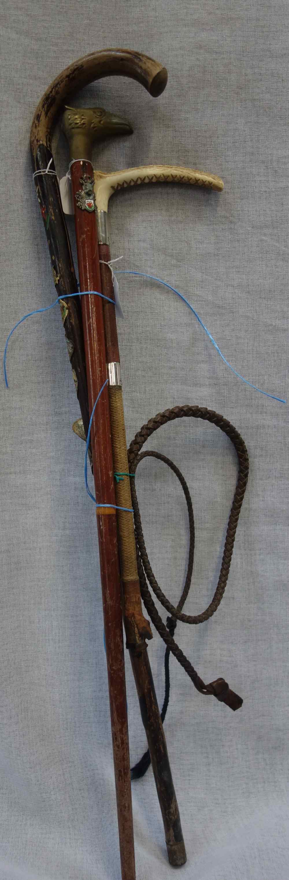 A HORN HANDLED RIDING CROP with silver ferrules and two walking sticks