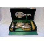 AN EDWARDIAN SILVER BACKED DRESSING TABLE SET, comprising four brushes, hand mirror and comb, each