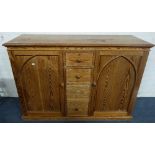 A VICTORIAN PITCH PINE SIDEBOARD, fitted two Gothic panelled doors and four central drawers, 137cm