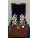 A VICTORIAN FIGURED WALNUT AND BRASS DECANTER BOX, containing four cut glass decanters