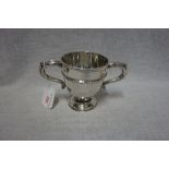 A SILVER TWIN HANDLED CUP, makers mark rubbed, London, 1916, circular form, leaf-capped scroll