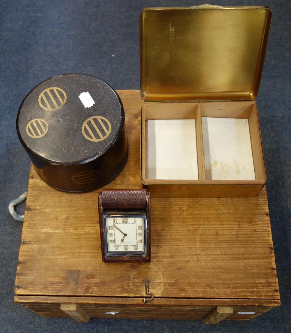 AN ORIENTAL LACQUERED CIRCULAR BOX, a 1930s leather covered travel clock, a wooden box and a brass