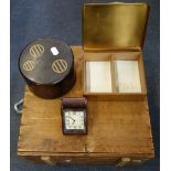 AN ORIENTAL LACQUERED CIRCULAR BOX, a 1930s leather covered travel clock, a wooden box and a brass