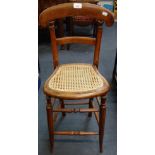 A VICTORIAN CANE SEATED CHILD'S HIGH CHAIR OR CORRECTION CHAIR