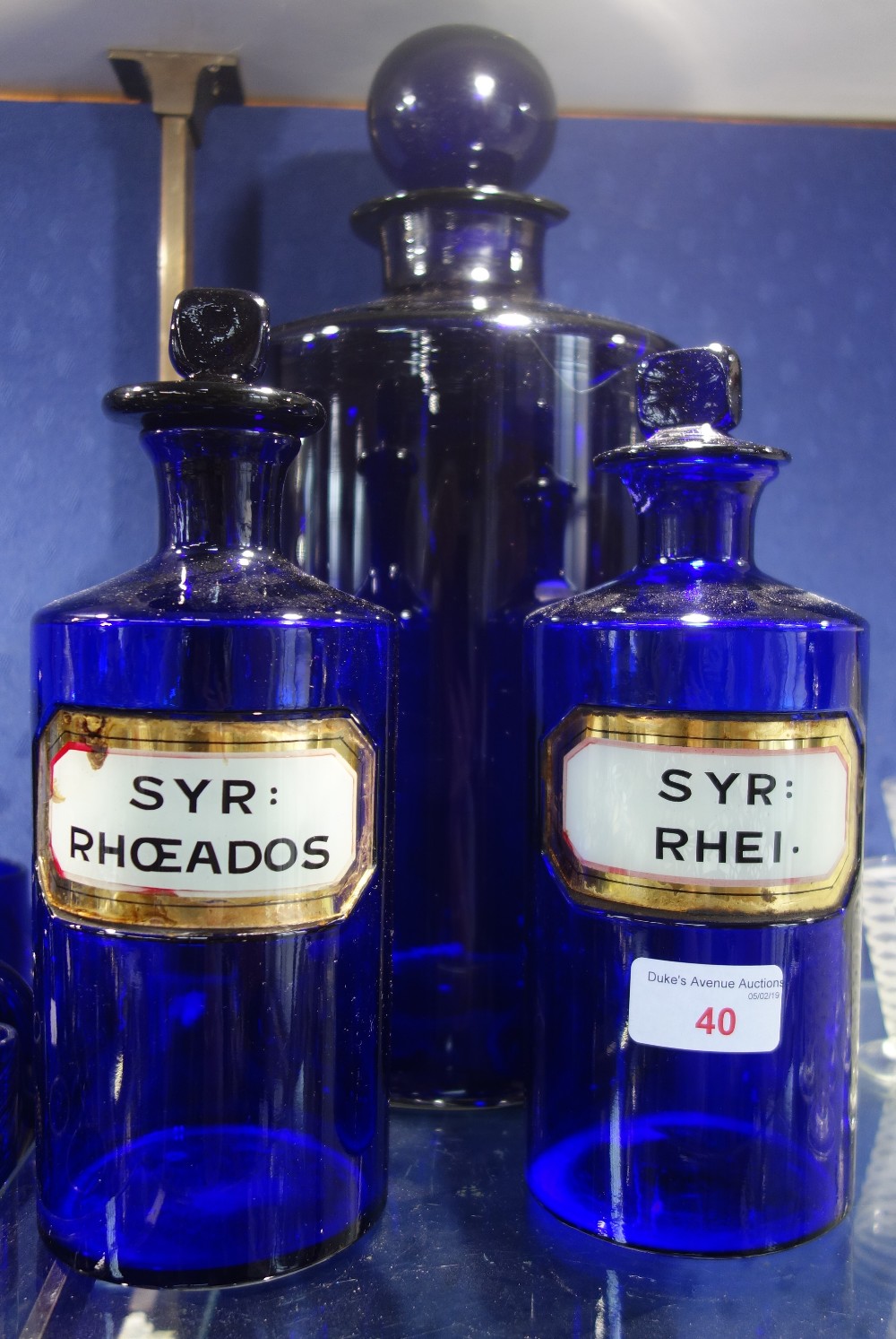 A PAIR OF 19TH CENTURY BRISTOL BLUE APOTHECARY JARS, 'SYR : RHEI.' and 'SYR : RHOEADOS' and a larger