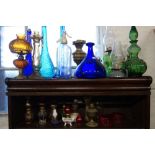 A COLLECTION OF COLOURED GLASSWARE, to include bottles, oil lamps and other similar items