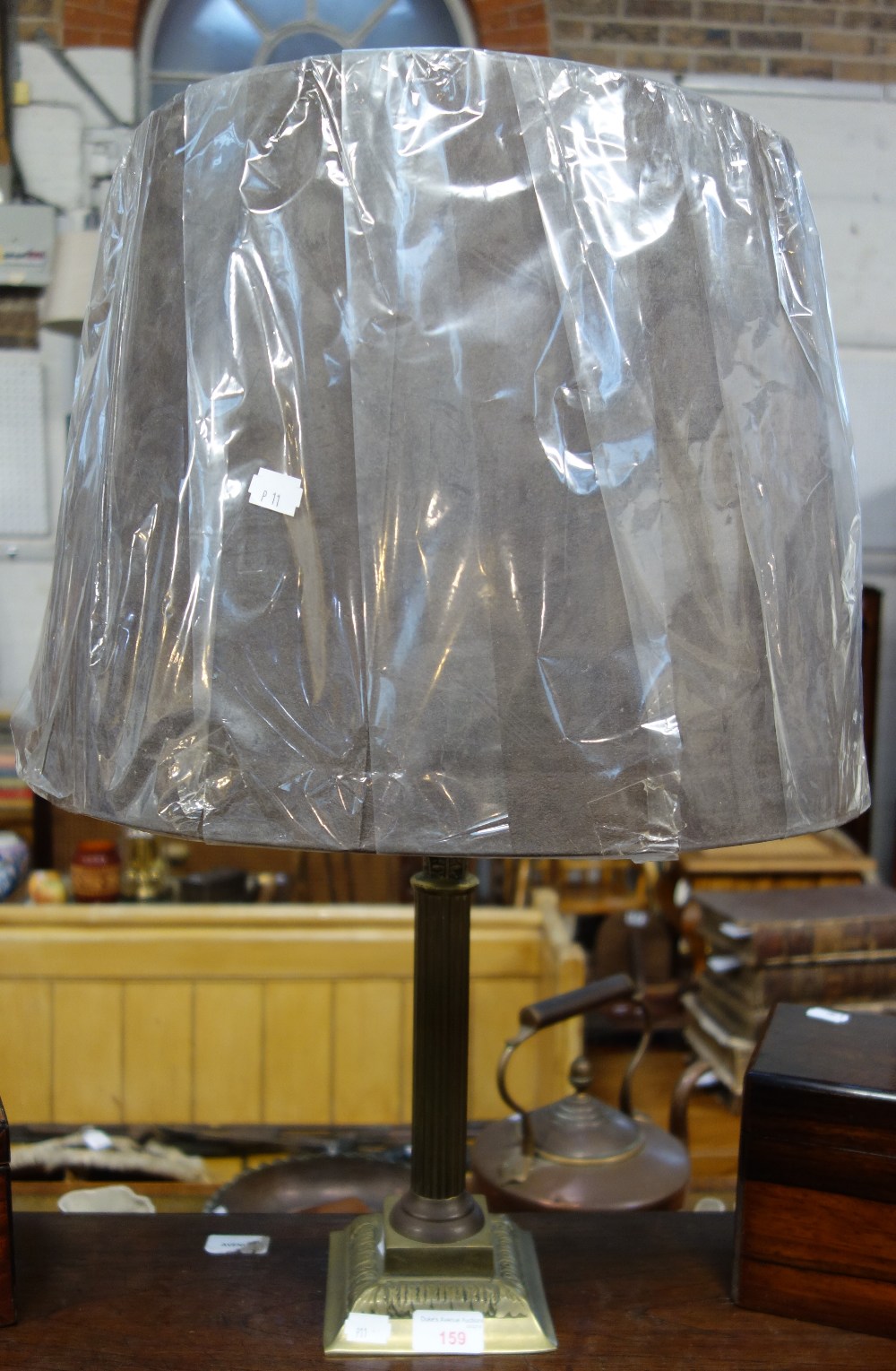 A BRASS CORINTHIAN COLUMN TABLE LAMP with a pleated shade