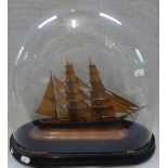 A VICTORIAN WOODEN MODEL OF A CLIPPER under a glass dome