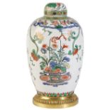 A CHINESE FAMILLE ROSE JAR AND COVER with gilt-bronze mounts, painted with flowering baskets,