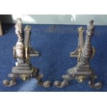 A PAIR OF CAST IRON AND BRASS FIRE DOGS, decorated with fabulous beasts