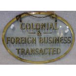 AN EARLY 20TH CENTURY OVAL GLASS SIGN, 'COLONIAL & FOREIGN BUSINESS TRANSACTED' 31.5cm high x 44cm